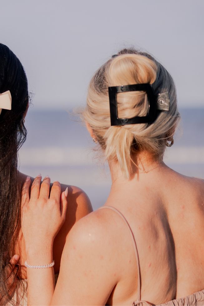 Large jet black square hair clip securing blonde hair