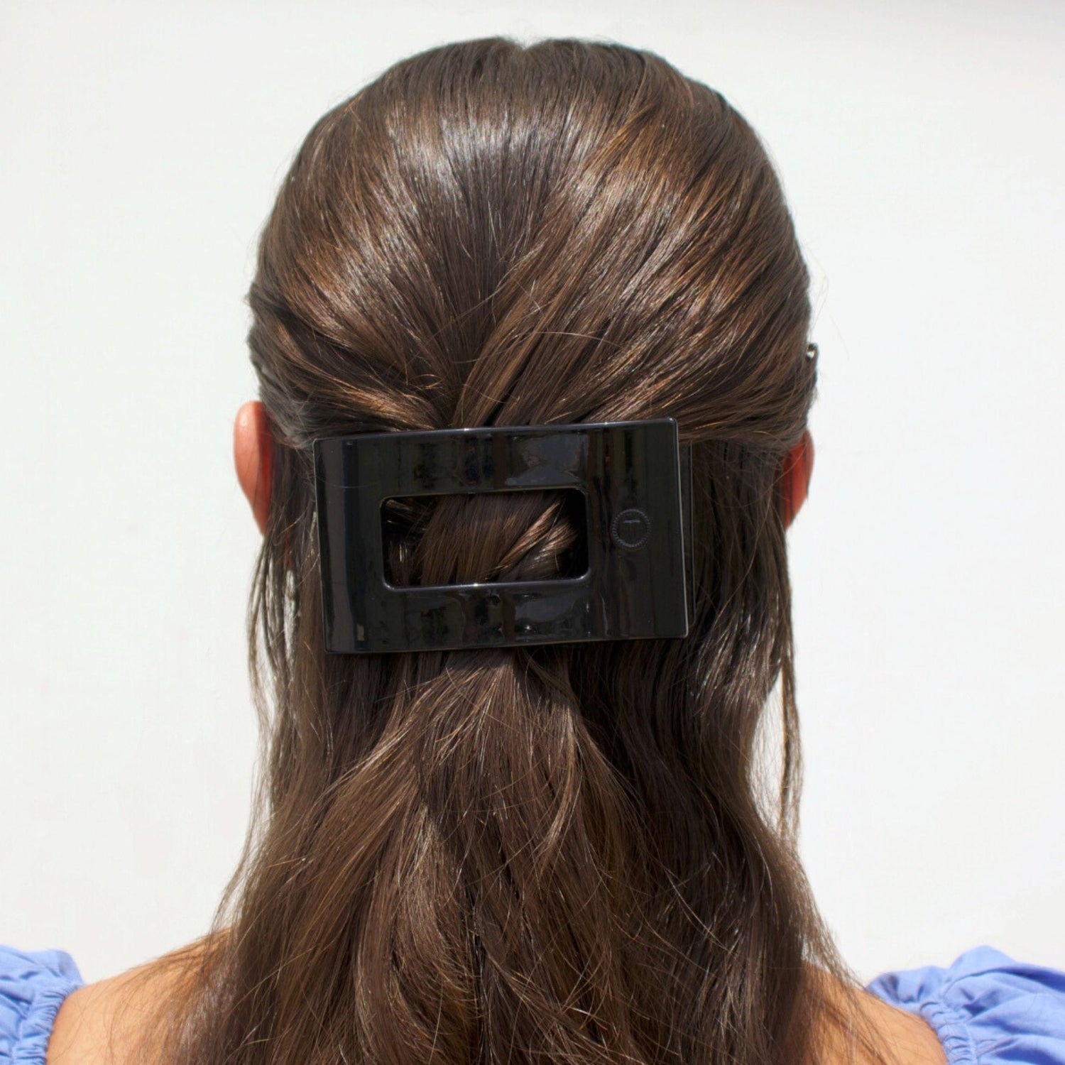 Jet black rectangle hair clip holding hair at the back