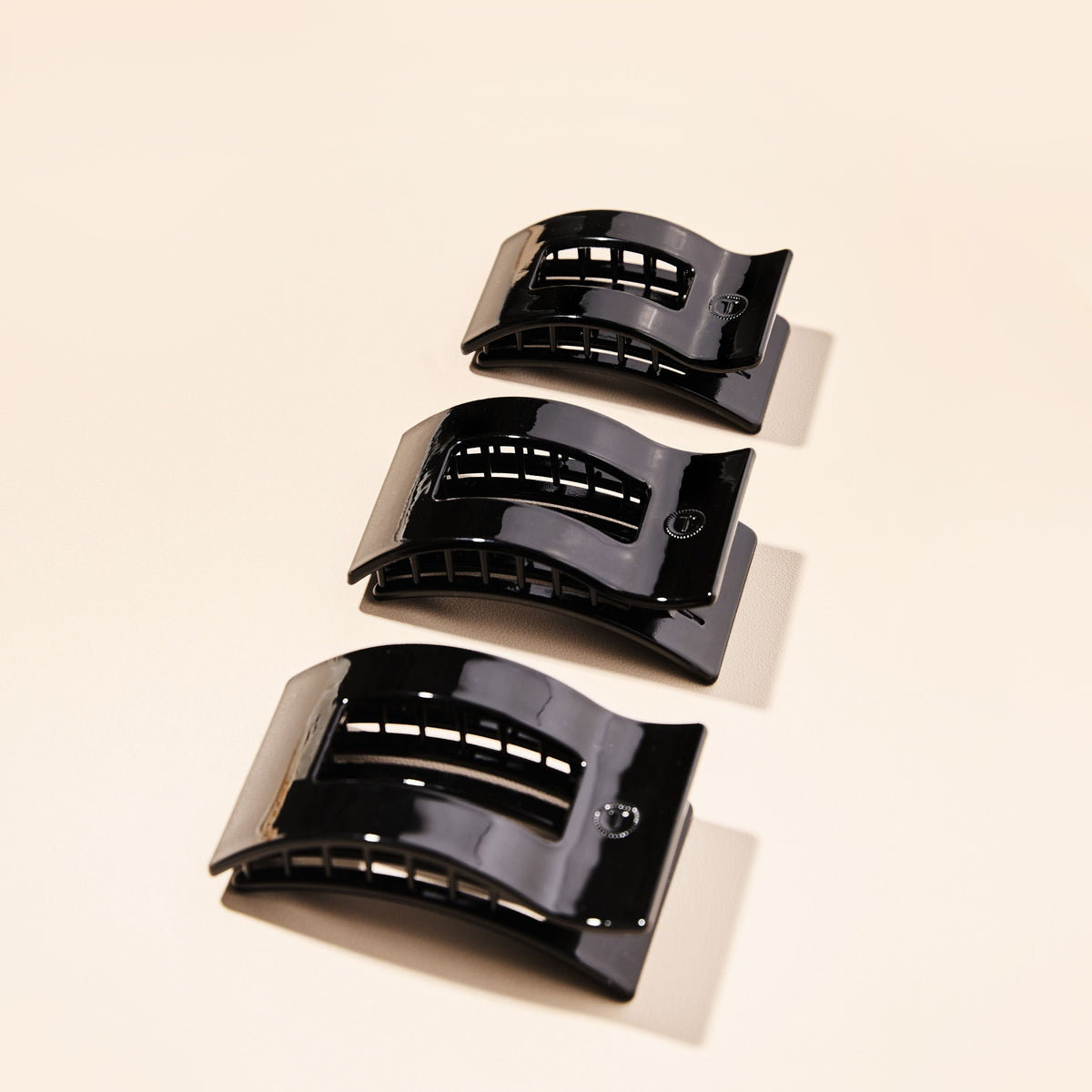 Set of black small flat rectangle hair clips in a three-piece stack