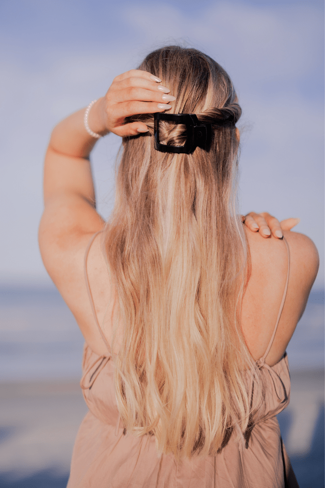 Jet black square flat hair clip holding long hair at the top of the head