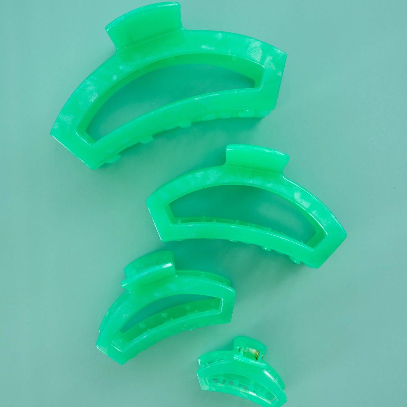 Assorted small mint-green open spring hair clips, four pieces.