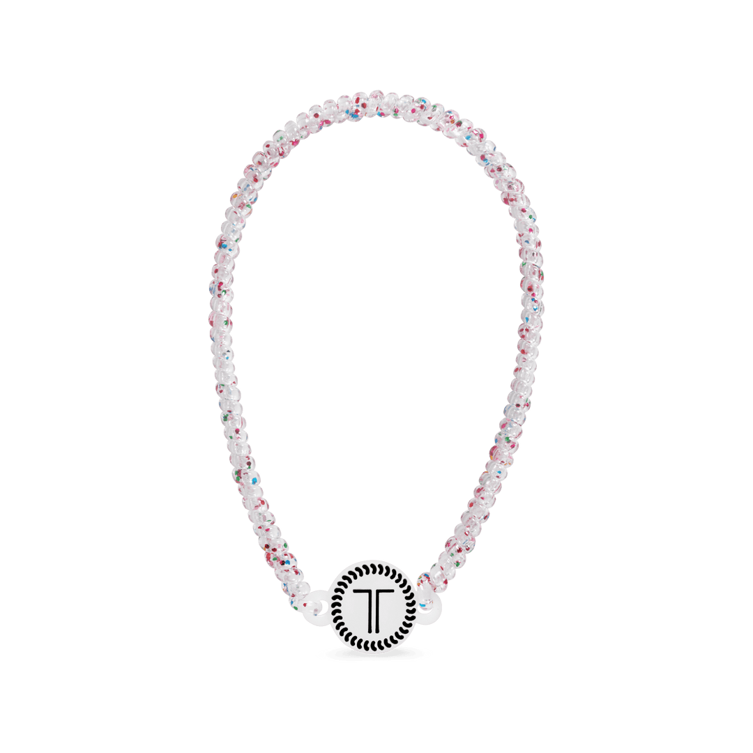 White beaded headband with rhinestone flowers and a round logo charm at front