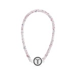 White beaded headband with rhinestone flowers and a round logo charm at front