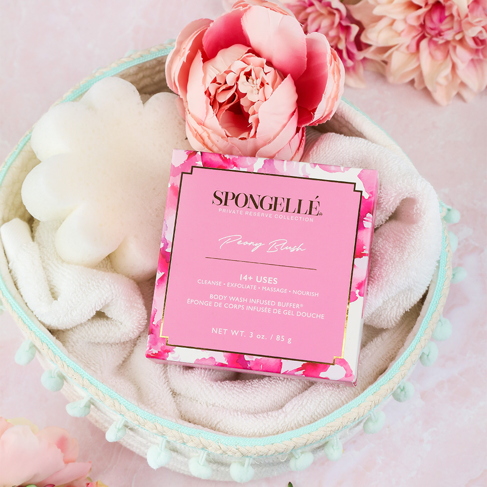 Peony blush body buffer in pink box, shown with flower-shaped sponge on tray