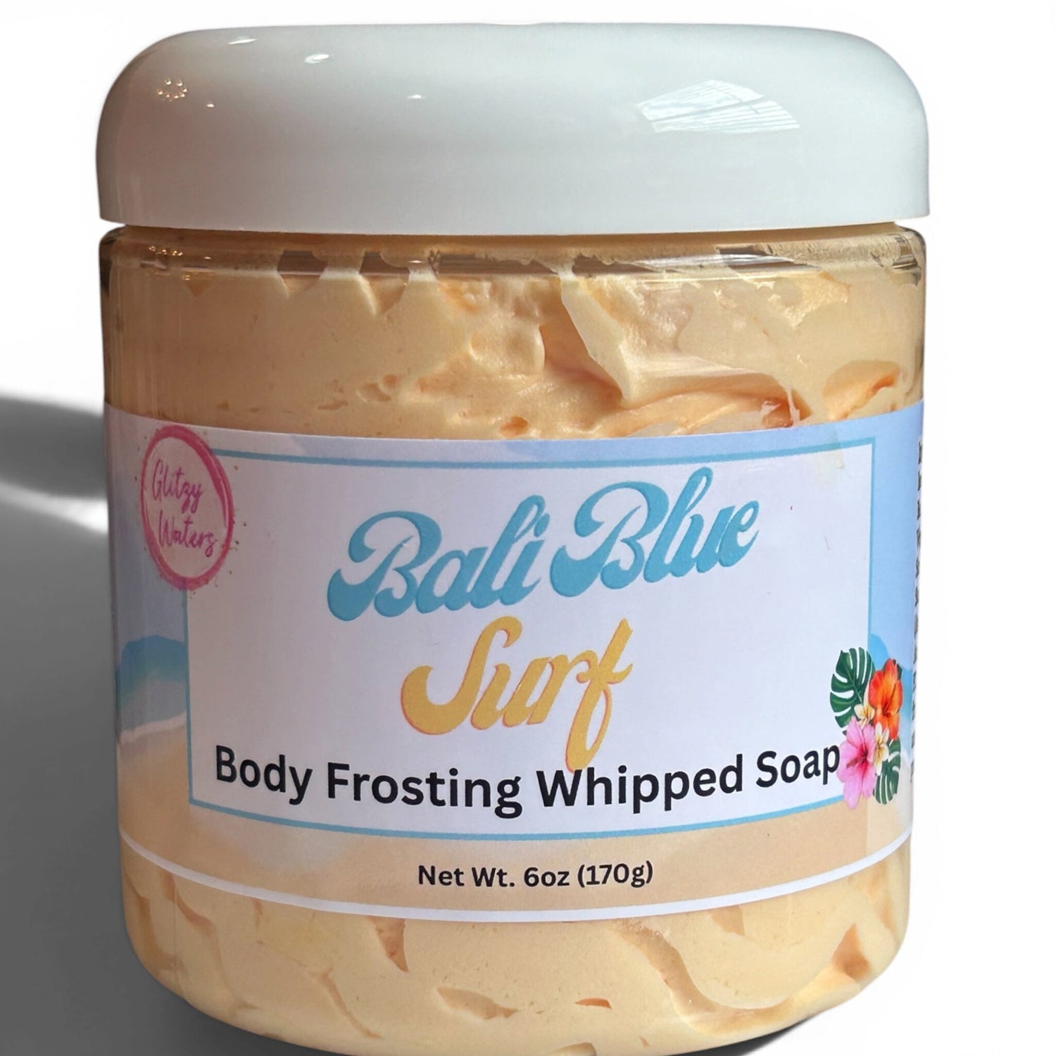 Whipped body frosting soap with clear container and white lid, creamy tan texture