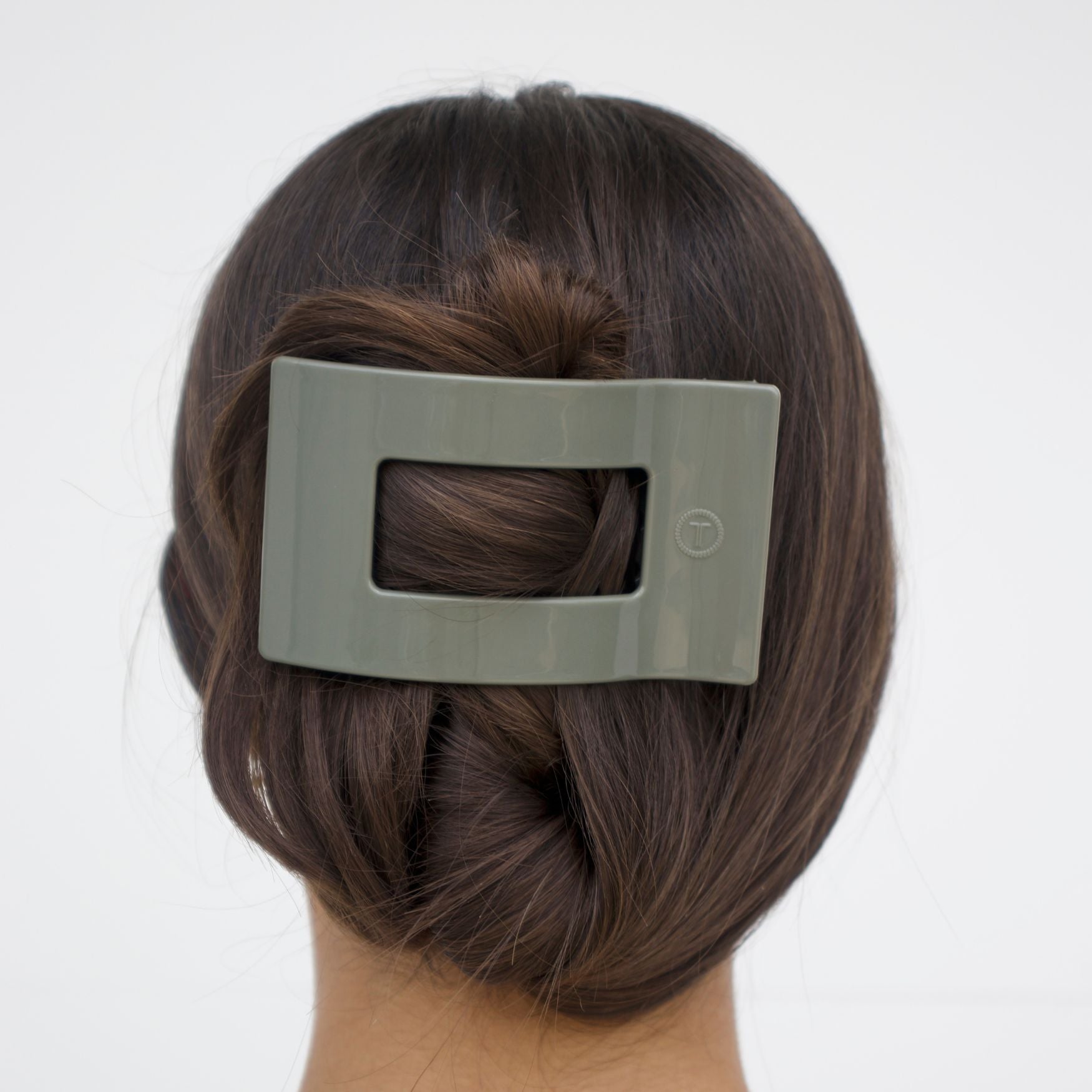 Sage green flat rectangle hair clip holding styled hair at the back