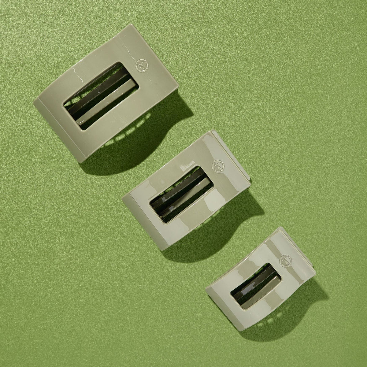 Set of large flat rectangle hair clips in sage green, three-pack view