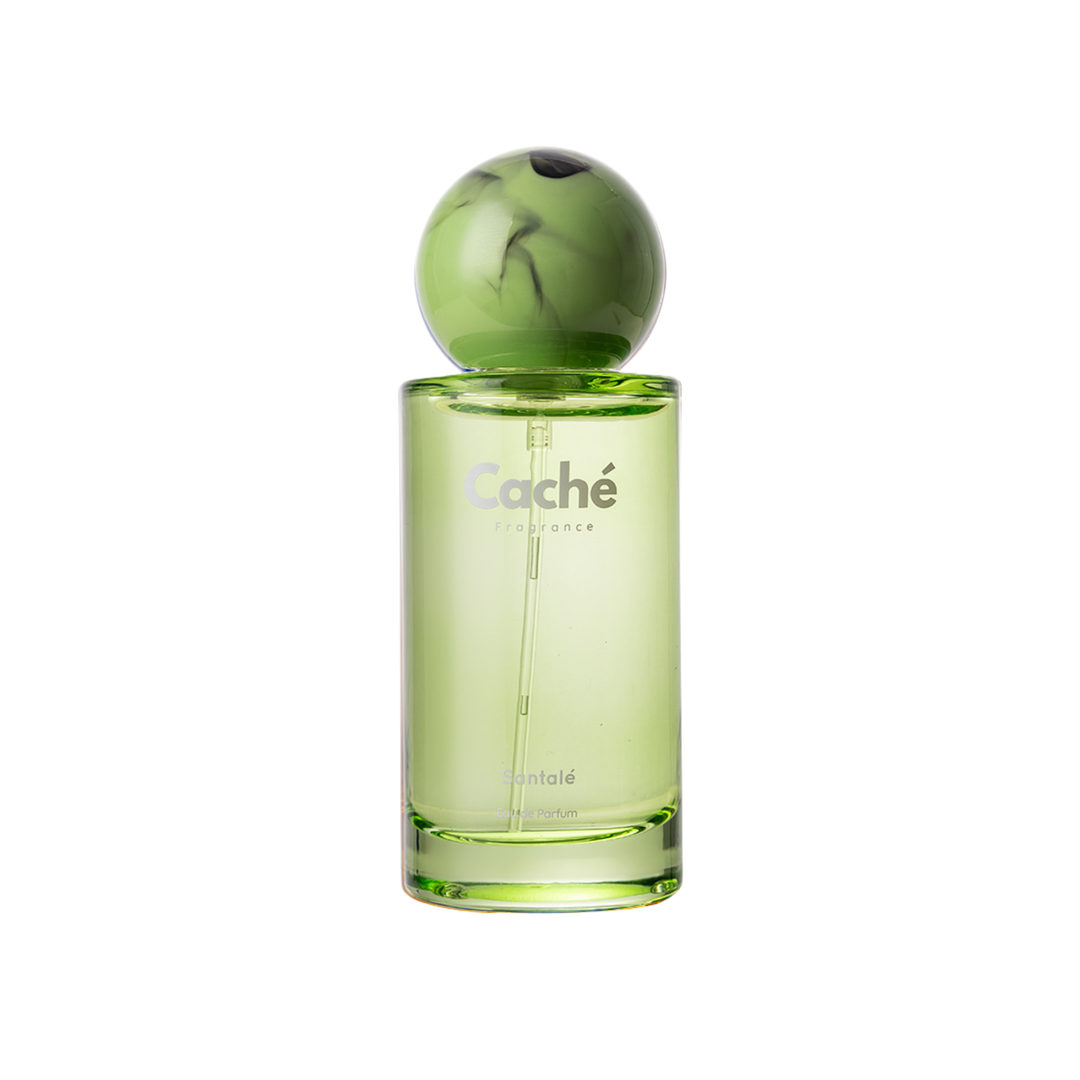 Green perfume bottle close-up with spherical cap, Cache label on clear glass body