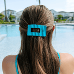 Medium flat rectangle hair clip in striped teal on a ponytail, with grip teeth