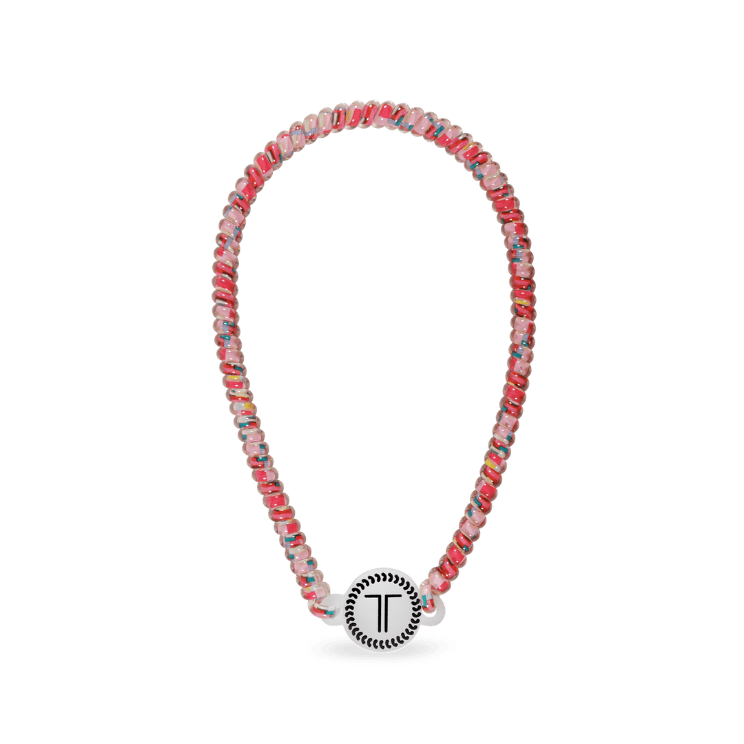 Beaded headband in pink, blue, and silver with a round black charm