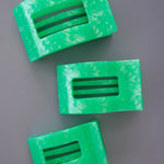 Set of large flat rectangle hair clips, translucent mint green with black bar accents.