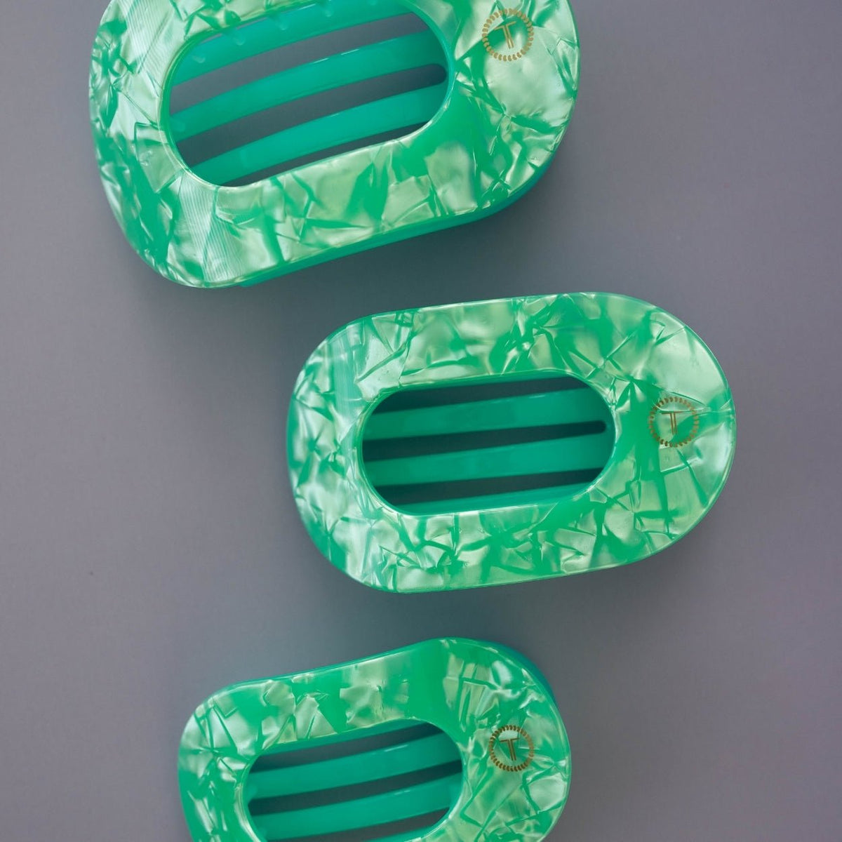 Large flat round hair clips, translucent mint green with black striped openings (3 shown)