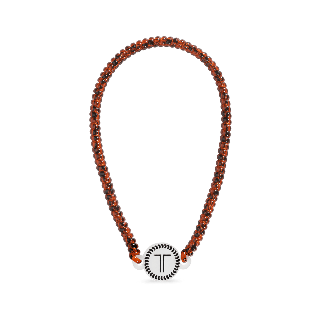 Beaded headband with orange-brown strands and a round white T charm centerpiece
