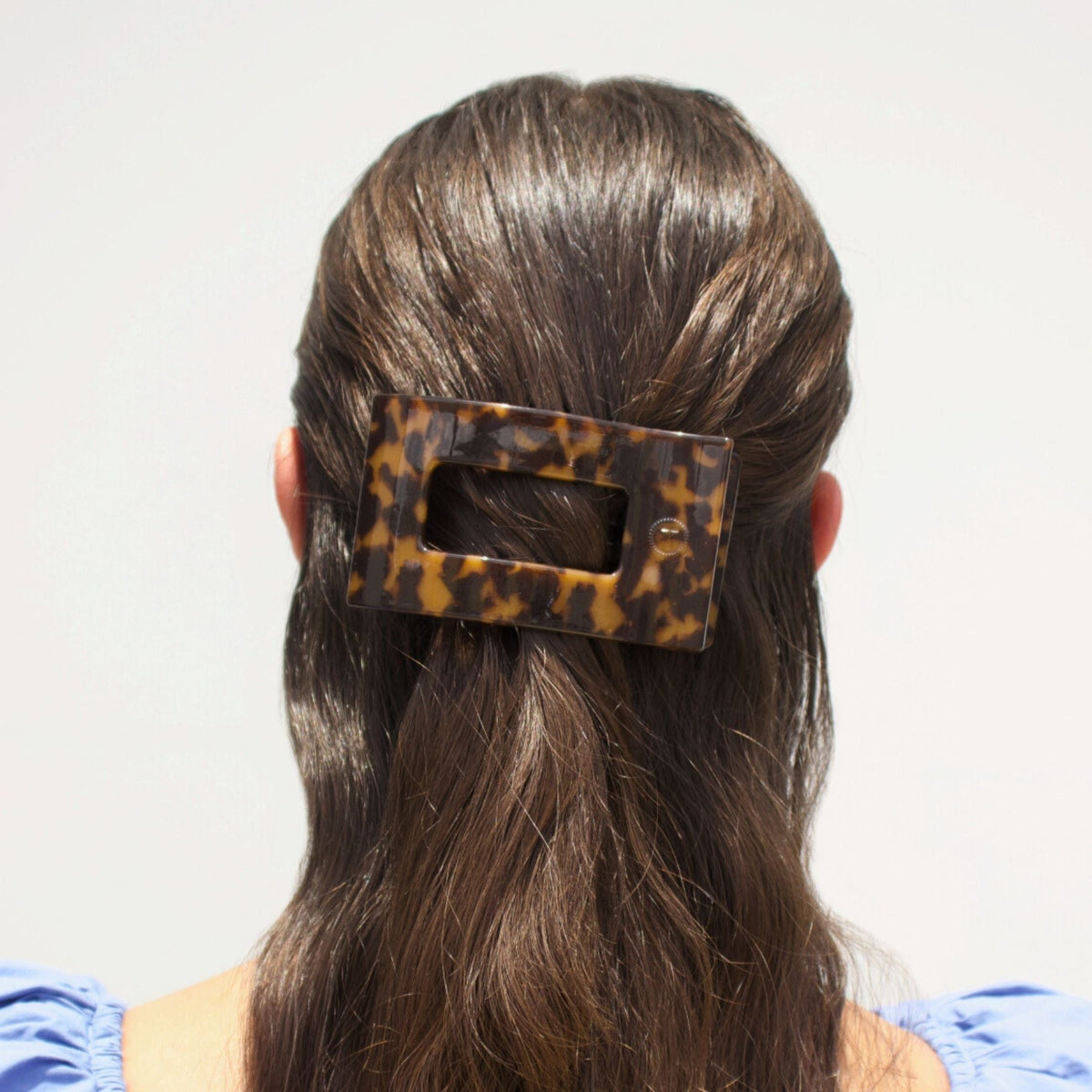 Rectangular tortoise-pattern hair clip holding hair at the back