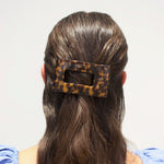 Rectangular tortoise-pattern hair clip holding hair at the back