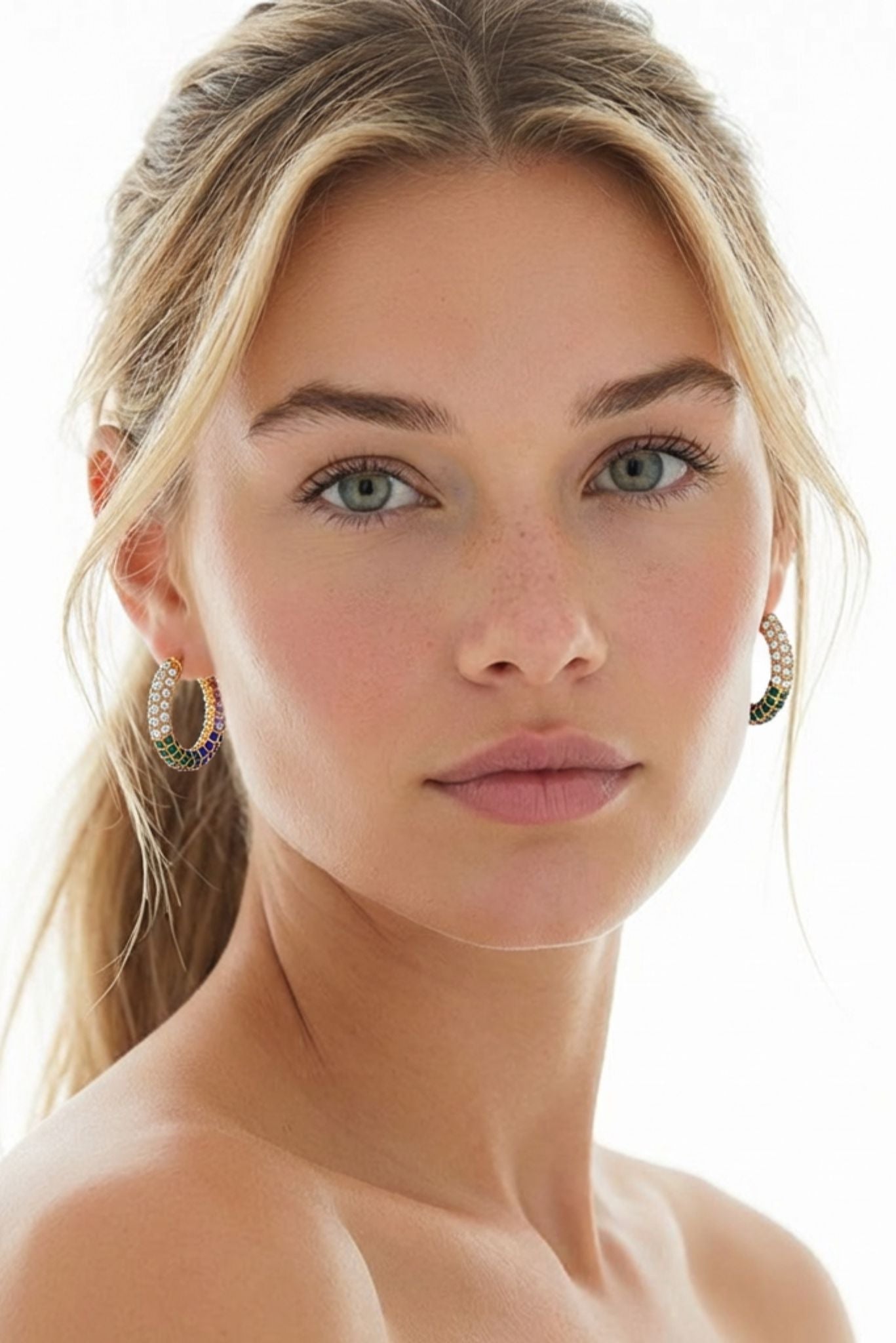 Multicolor rhinestone hoop earrings worn by a model, gold-tone with circular halo